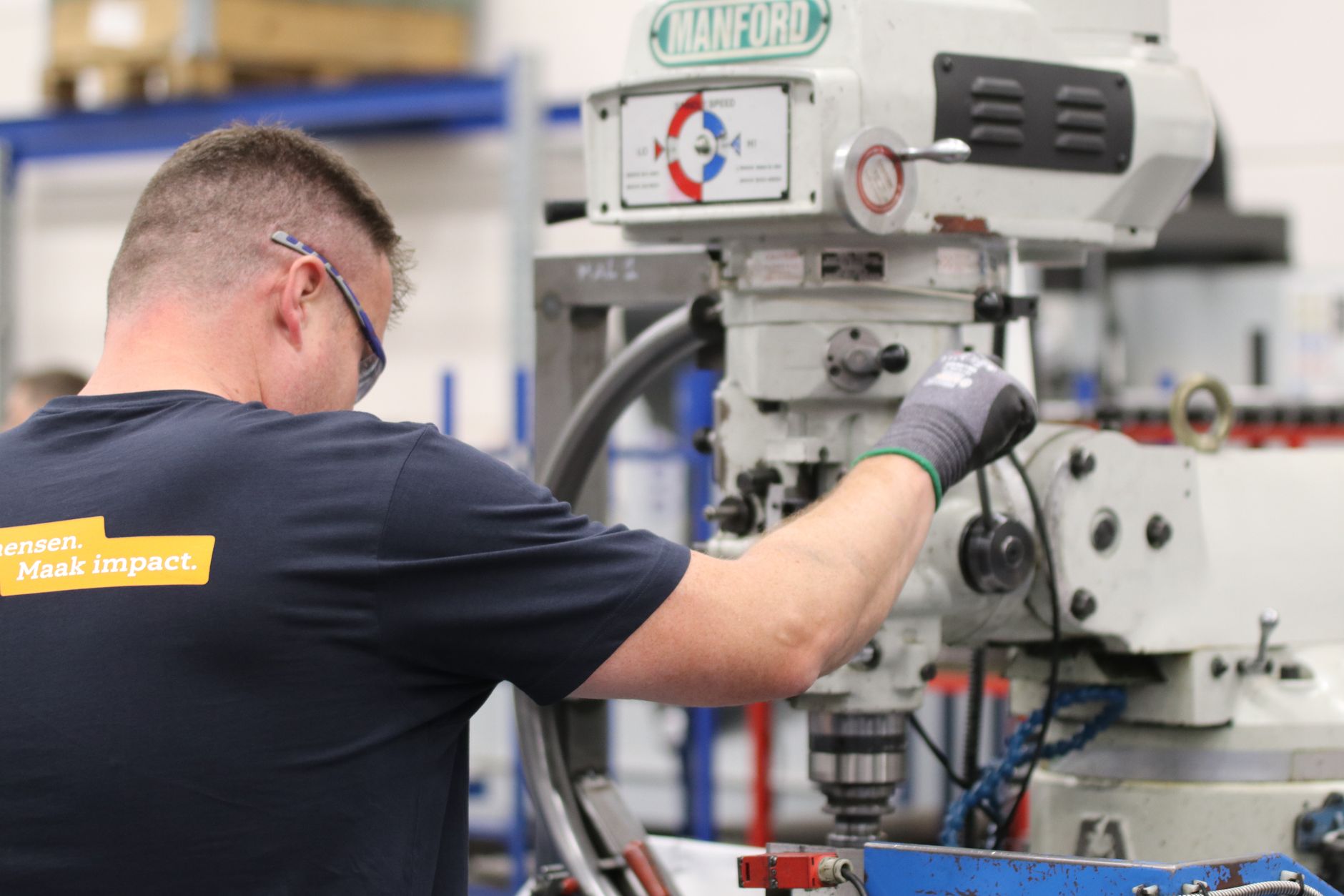 A machinist operating a milling machine on the shop floor